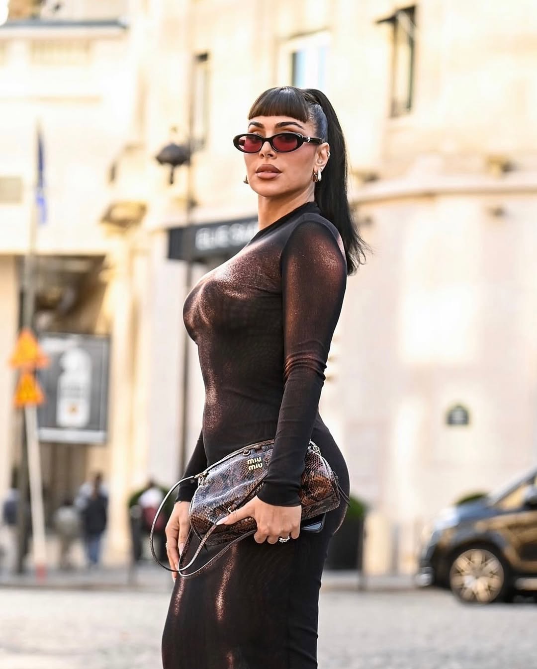 Huda Kattan wears a brown-bronze dress for the Paris Fashion Week